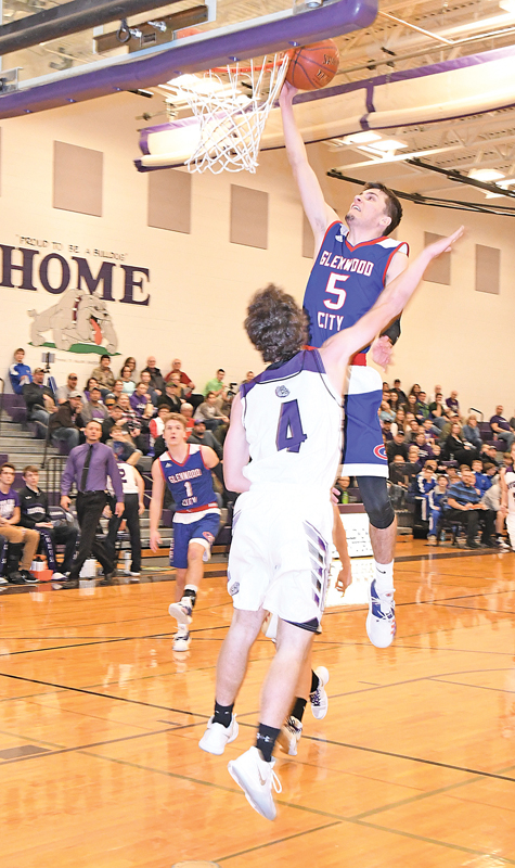 GLENWOOD CITY senior Hadin DeSmith glided high over Boyceville defender Brendan Sempf to score two of his game-high 21 points in Hilltoppers' 77-26 victory over the Bulldogs in Boyceville last Friday, January 4. —photo by Shawn DeWitt