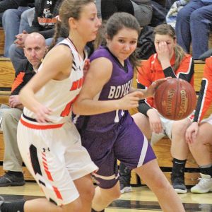 FIGHTING FOR THE LAY UP— Emma Ouellette (#11) fights off defender Alana Plaszcz (#13) on her way to the net for two. —photo by Amber Hayden