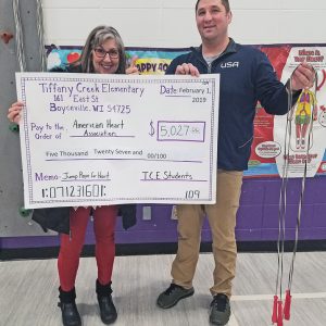 TCE MAKES DONATION — Corey Day, Tiffany Creek Elementary physical education teacher, handS off a check to Renee Davis of the American Heart Association. The month of January was a huge success for the fight against heart disease and stroke. Tiffany Creek Elementary students took on healthy heart challenges online, learned about nutrition, physical activity, being tobacco free and some awesome jump rope skills in physical education. Students also took part in raising money for the American Heart Association. Tiffany Creek Elementary had a goal of raising $3,500, which they crushed, collecting $5,027 in donations! —submitted photo