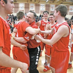 A TIME TO CELEBRATE — Jubilant assistant coach Tim Devine embrassed player Jackson Hellman following the Colfax Vikings 75-72 double-overtime, regional championship win over Webster last Saturday. —photo by Shawn DeWitt