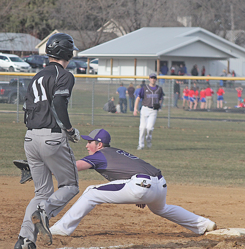 EXTENDED REACH — First basemanTrevor Hollister (#2) stretched out into almost the splits in order to catch the ball from Boyceville's third basemen to put out Elmwood/Plum City runner Jackson Glampe (#11). The Bulldogs went on to win the Tuesday night, April 16 battle, 12-2, in five innings. —photo by Amber Hayden