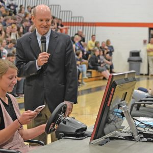 IT CAN WAIT — Jim Jermain of AT&T explains to a student volunteer at Elk Mound High School April 16 how the AAA distracted driving simulator works. The program was part of AT&T's "It Can Wait" campaign highlighting the dangers of distracted driving. The four student volunteers were asked to look at their cell phones while "driving" the simulator. All of the students had near misses, crashes or ran stop signs or stop lights while looking at their cell phones. —photo by LeAnn R. Ralph