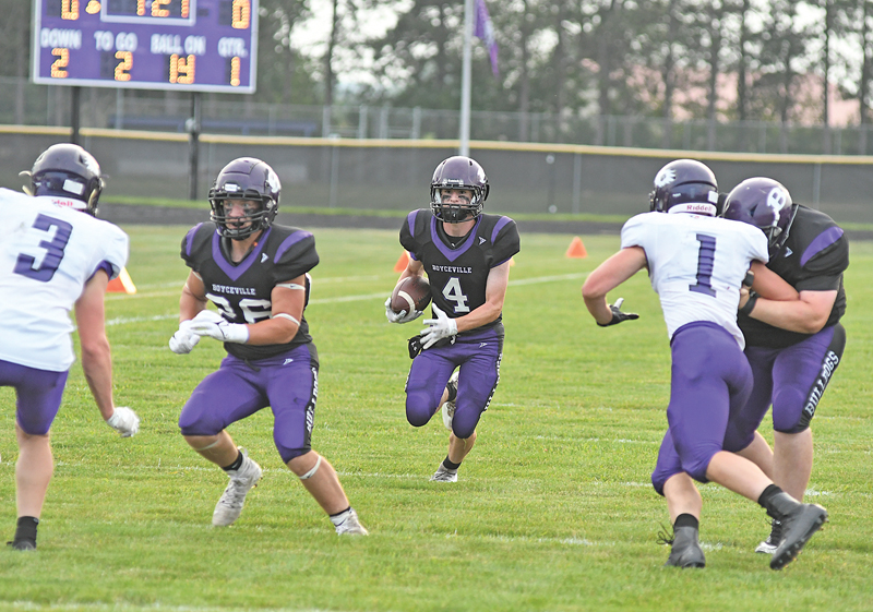 RUNNING TOWARD an opening created by his linemen, Boyceville’s Nick Olson (#4) gain positive yards on this play during the Bulldogs’ home and season football opener against Independence/Gilmanton last Friday, August 20. Olson eventually scored the game’s first touchdown, a 9-yard jaunt, on this drive to give Boyceville an early 6-0 lead after one quarter of action. The Bulldogs went on to thump the Indees by a count of 47-6.—photo by Shawn DeWitt