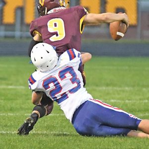 TACKLED FOR A LOSS — The Toppers’ Justin Moe (#23) pulled down Golden Bears’ quarterback Colin Kappel for a loss in the second quarter. Glenwood City earned its first win of the season, a 15-8 road win in Barron August 27. —photo by Shawn DeWitt