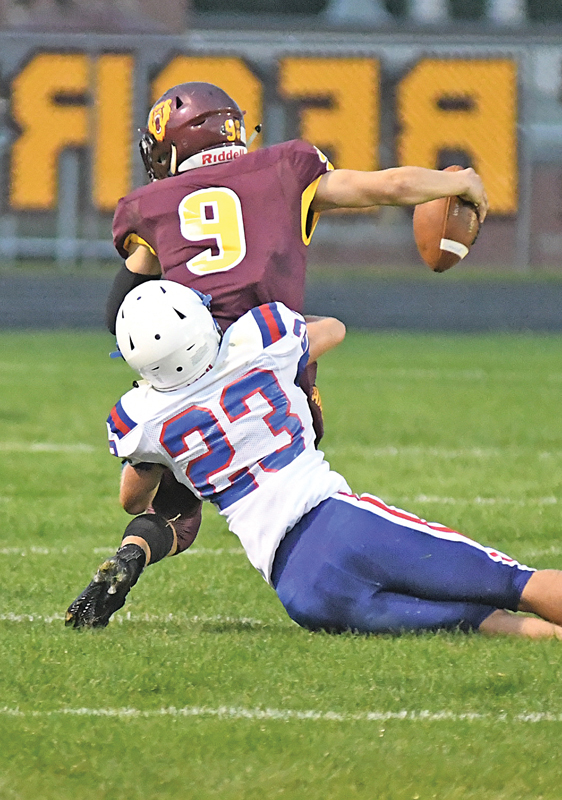 TACKLED FOR A LOSS — The Toppers’ Justin Moe (#23) pulled down Golden Bears’ quarterback Colin Kappel for a loss in the second quarter. Glenwood City earned its first win of the season, a 15-8 road win in Barron August 27. —photo by Shawn DeWitt