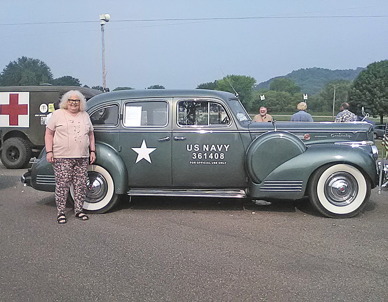 GLENWOOD CITY resident Lois Kilde had her picture taken in front of a World War II vintage military vehicle when the Military Vehicle Preservation Association (MVPA) conoy, which is a highlight of the 2021 Yellowstone Trail Heritage Days Celebration, stopped for a break at Knapp Memorial Park last Saturday morning, July 31. The convoy features privately-owned and restored trucks, jeeps, ambulances, troop and equipment carries, and other transports that are driving cross-country for 23 days on the Yellowstone Trail (US Highway 12). The convoy started in Aberdeen, South Dakota and will end in Ohio. The St. Croix County leg of the journey took place this past Friday and Saturday, July 30 and 31, as the convoy passed through Hudson, Roberts, Hammond, Baldwin, Woodville, and making a brief stop in Knapp before continuing on. —photo submitted