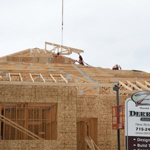DAILY PROGRESS is being made on the City of Glenwood City’s new municipal building which will house the city government, police department, public library and community center when completed. In the photograph above, workers helped guide a section of roof trusses into position August 5. The nearly $2.5 million project is being built on the former site of the old community center located on the north side of East Oak Street. —photo by Shawn DeWitt