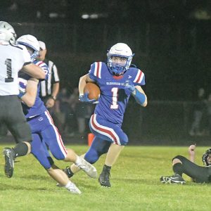 WITH A LITTLE blocking help from teammates Justin Moe (left) and Noah Brite, senior Brady McCarthy (#1) was able to run to the outside for a nice gain in the September 10 home opener versus Elmwood/Plum City. McCarthy finished with 80 yards and a touchdown on seven carries. However, it was not enough s the Wolves won 32-20. —photo by Shawn DeWitt