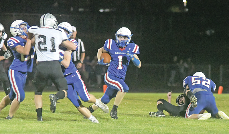 WITH A LITTLE blocking help from teammates Justin Moe (left) and Noah Brite, senior Brady McCarthy (#1) was able to run to the outside for a nice gain in the September 10 home opener versus Elmwood/Plum City. McCarthy finished with 80 yards and a touchdown on seven carries. However, it was not enough s the Wolves won 32-20. —photo by Shawn DeWitt 