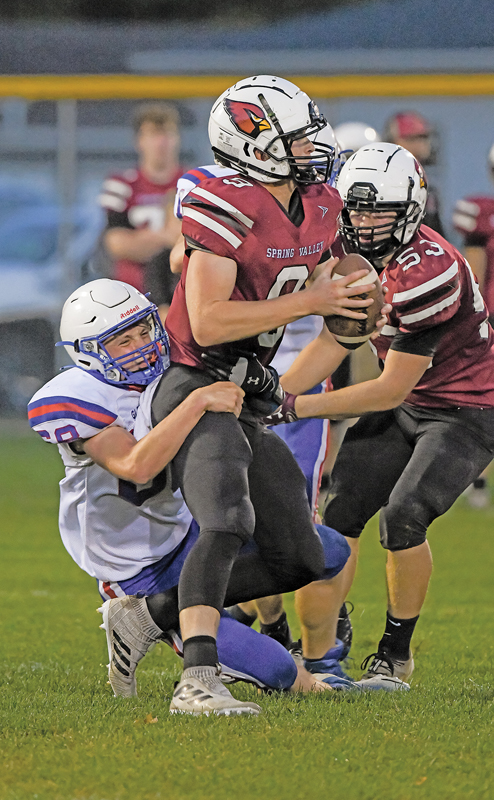 HILLTOPPER defenseman Nick Hierlmeier took down Spring Valley quarterback Connor Ducklow behind the line of scrimmage to register a sack in a September 17 football contest played on the Cardinals’ home turf. Spring Valley won the conference clash 42-10. —photo by Jacob Maes Photography