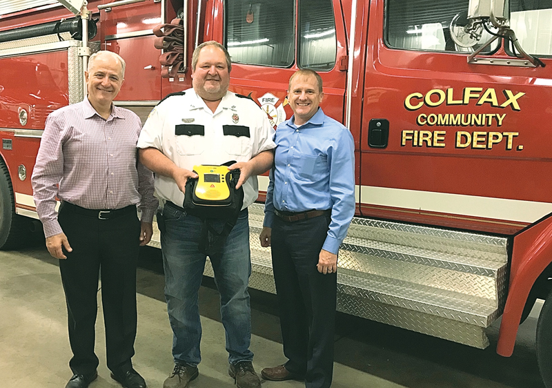FIRE CHIEF — Don Logslett, Colfax fire chief, accepted an Automatic External Defibrillator (AED) donated by Dr. Anton Kidess (on left) and Dr. Erik Dickson of Oakleaf Medical Clinic in Eau Claire at the Colfax fire station in January of 2020. The donation of a second AED means that both fire engines each have one on board. — photo submitted