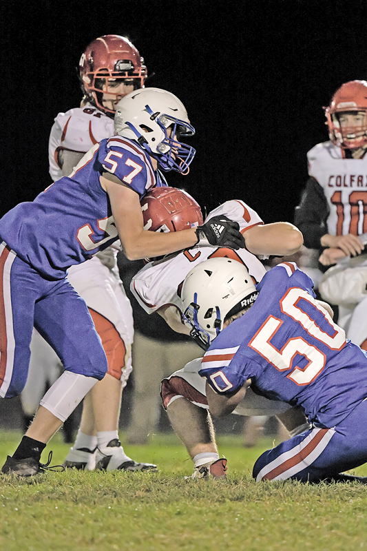 TEAM TACKLE — Glenwood City seniors Collin LaValley (#57, left) and Carter Clemens (#50) combined to bring down a Colfax ball carrier during the Toppers' Homecoming game last Friday, October 15. Glenwood City won the game 55-0. —photo by Jacob Maes Photography