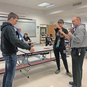 HOW TO TIE A TIE — Boyceville superintendent Nick Kaiser demonstrating to Riley Schutz and Jack Gruenhagen on how to tie a tie. —photo submitted