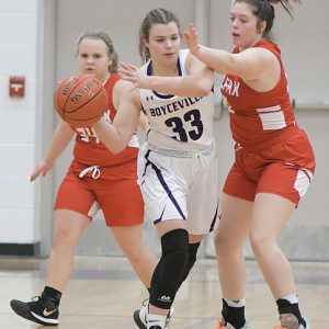 THE BULLDOGS’ Abby Schlough (#33) looked to pass the ball during a December 17 home game versus Colfax. Schlough posted three points in the 59-24 loss to the Vikings. —photo by Shawn DeWitt