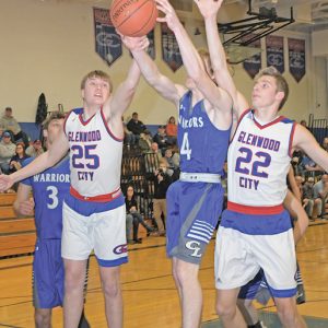 GLENWOOD CITY’S Owen Swenby (#25, left) and Elek Anderson (#22, right) battled a Clear Lake player for a rebound during a January 4 non-conference basketball game played on the Toppers home court. —photo by Shawn DeWitt