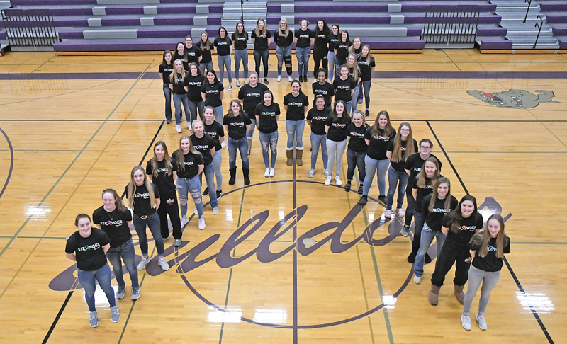 TEAMING UP TO FIGHT CANCER — Players on the Boyceville and Colfax girls' basketball teams stood in solidarity February 14 in the fight to end cancer. Together, players on both squads formed a ribbon in Boyceville's High School gym to kick off the 8th annual "Coaches versus Cancer" fundraiser before donning their respectively school colors to do battle on the hardwood. The event fetured a silent auction, raffles, and food with all proceeds going to the American Cancer Society to aid in its search for cures. —photo by Shawn DeWitt