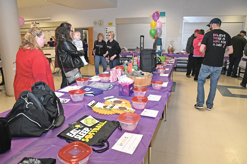 SO MANY CHOICES — People perused the many items available in the raffle and silent auctions during the 8th annual Coaches versus Cancer event held Thursday, February 14 at the Boyceville High School commons prior to and during the Boyceville girls' basketball game against Colfax. The event is organized and hosted by boosters, coaches, teachers and parents of the Bulldogs girls basketball team and raises funds for the Amercian Cancer Society. —photo by Shawn DeWitt